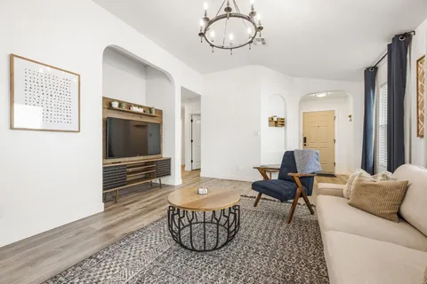 a living room with furniture a flat screen tv and a window