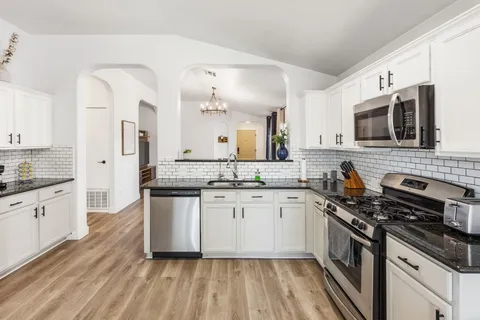 a kitchen with stainless steel appliances a sink dishwasher stove refrigerator and microwave