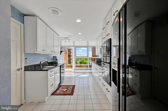 a kitchen with granite countertop a stove a sink and a refrigerator