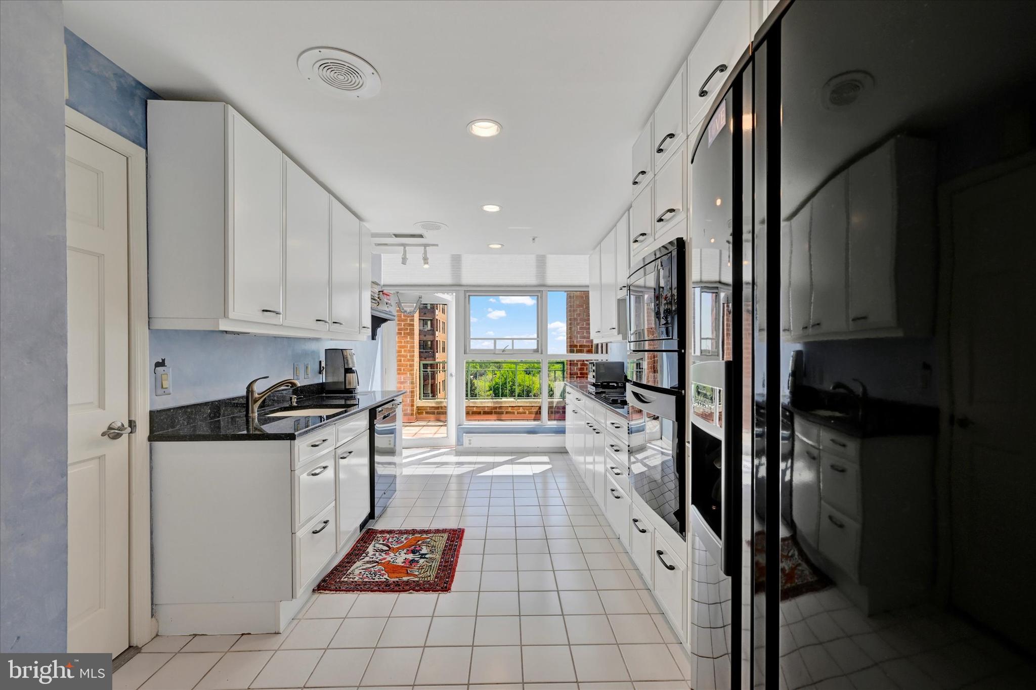 3801 Canterbury Road, Unit 1002 Baltimore, MD 21218 - Photo 11 of 32 a kitchen with granite countertop a stove a sink and a refrigerator
