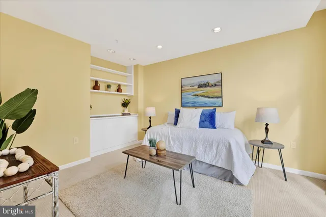 a bedroom with a bed and a potted plant on the dresser