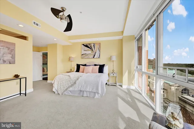 a bedroom with a bed next to a large window with the outer view