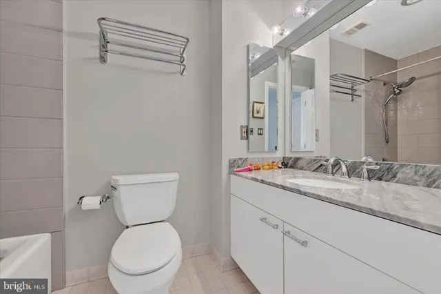 a bathroom with a toilet sink vanity and mirror