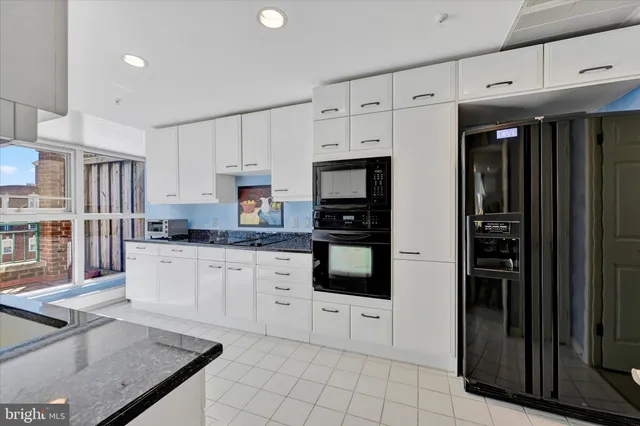 a kitchen with stainless steel appliances granite countertop a refrigerator sink and cabinets
