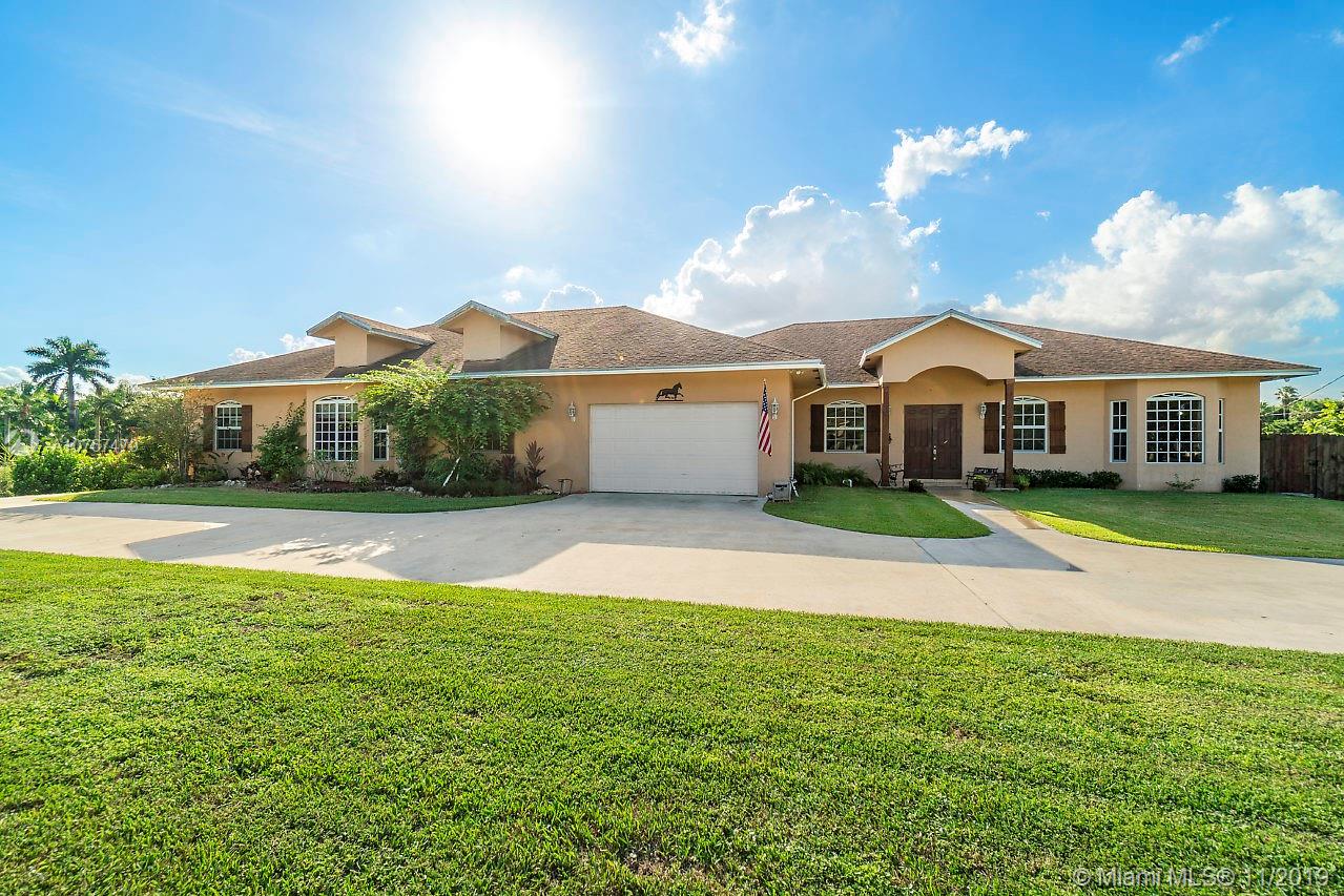 6915 Southwest 185th Way Southwest Ranches, FL 33332 - Photo 1 of 48 a front view of a house with a garden and yard