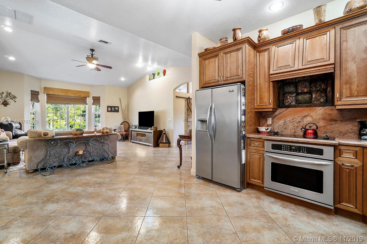 6915 Southwest 185th Way Southwest Ranches, FL 33332 - Photo 24 of 48 a kitchen with refrigerator a stove a washer dryer and cabinets