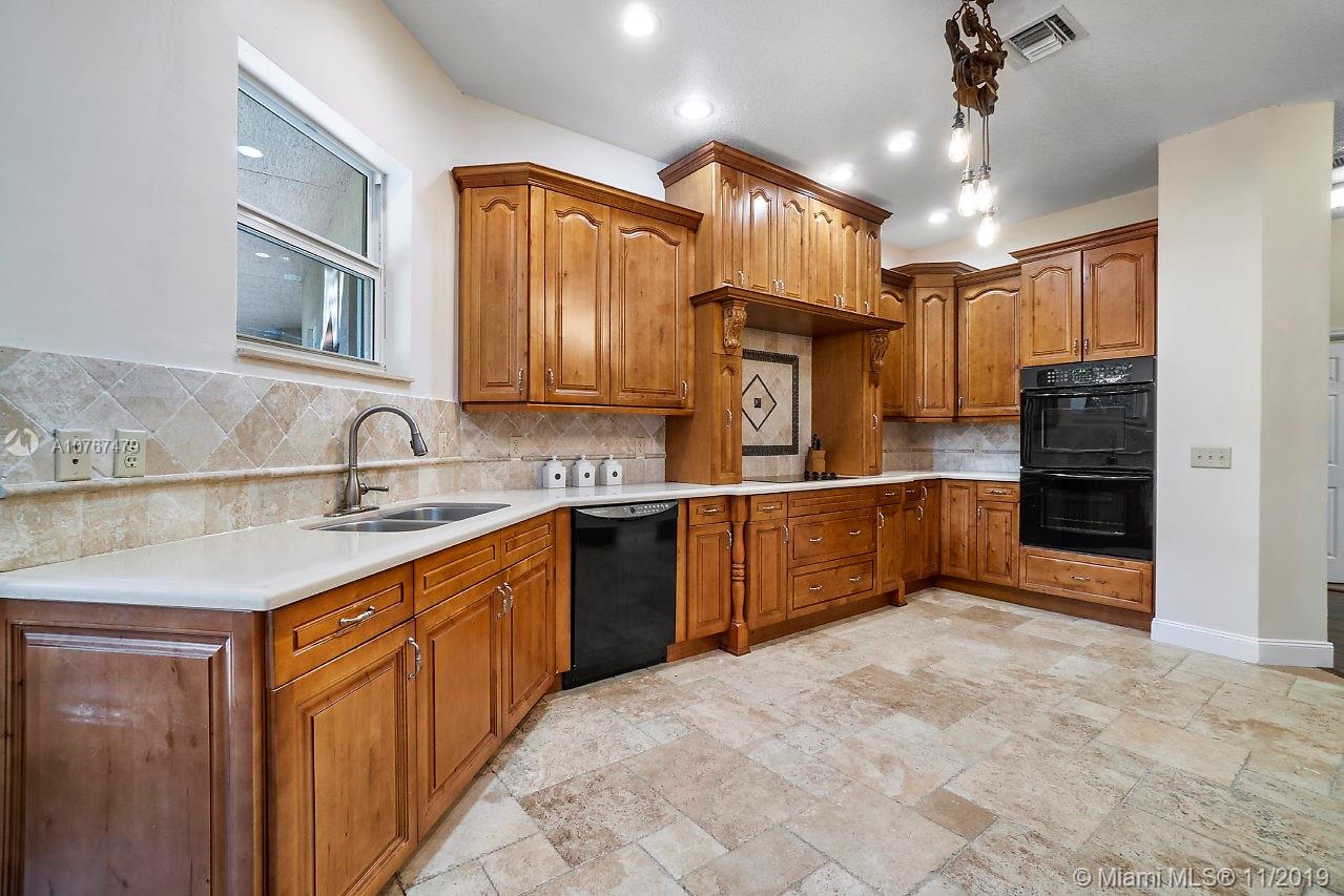 6915 Southwest 185th Way Southwest Ranches, FL 33332 - Photo 6 of 48 a large kitchen with stainless steel appliances kitchen island granite countertop a sink refrigerator and cabinets