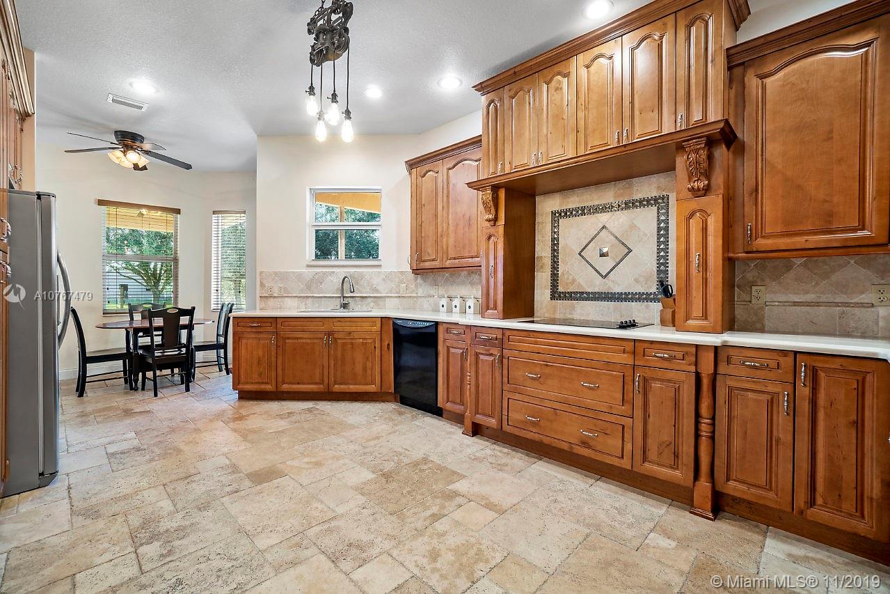 6915 Southwest 185th Way Southwest Ranches, FL 33332 - Photo 7 of 48 a kitchen with granite countertop a sink cabinets and window