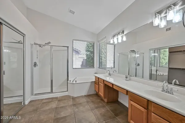 a spacious bathroom with a shower a sink and a large mirror