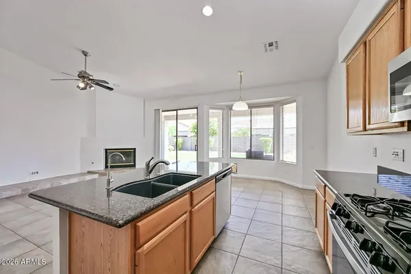 a kitchen that has a sink a stove and a table in it