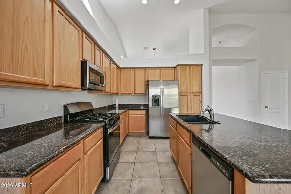 a kitchen with stainless steel appliances granite countertop a sink stove and refrigerator