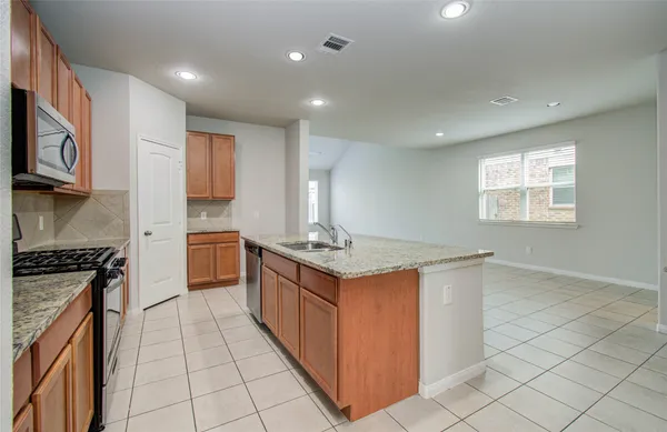 a kitchen with stainless steel appliances granite countertop a refrigerator sink and microwave