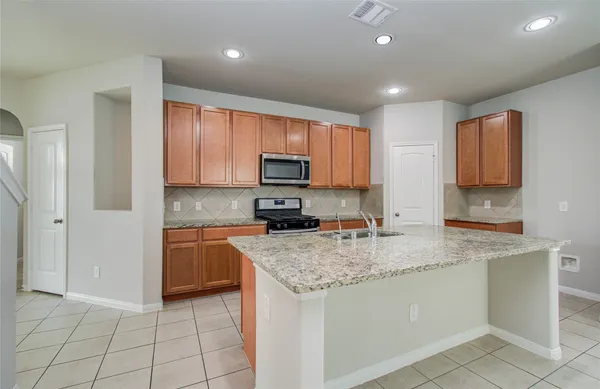 a kitchen with stainless steel appliances granite countertop a sink stove and cabinets