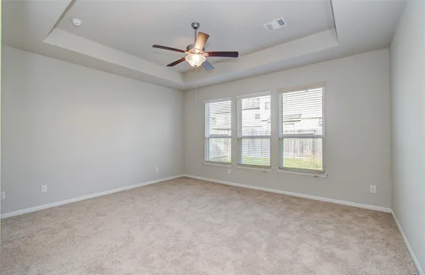 a view of an empty room with a chandelier fan