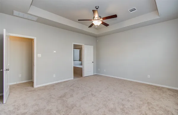 an empty room with closet and a ceiling fan