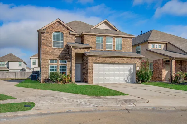 a front view of a house with a garden and garage