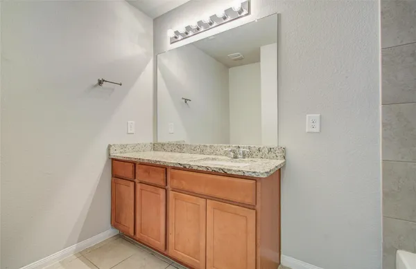 a bathroom with a granite countertop tub sink and shower