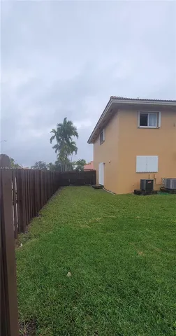a backyard of a house with lots of green space and plants