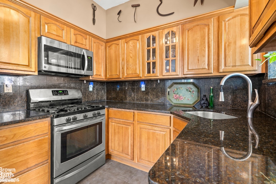 2954 Avenue R Brooklyn, NY 11229 - Photo 14 of 37 a kitchen with stainless steel appliances granite countertop a stove a sink and a microwave