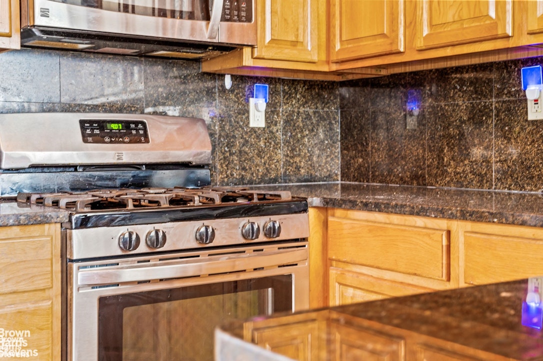 2954 Avenue R Brooklyn, NY 11229 - Photo 15 of 37 a kitchen with stainless steel appliances granite countertop a stove and a microwave