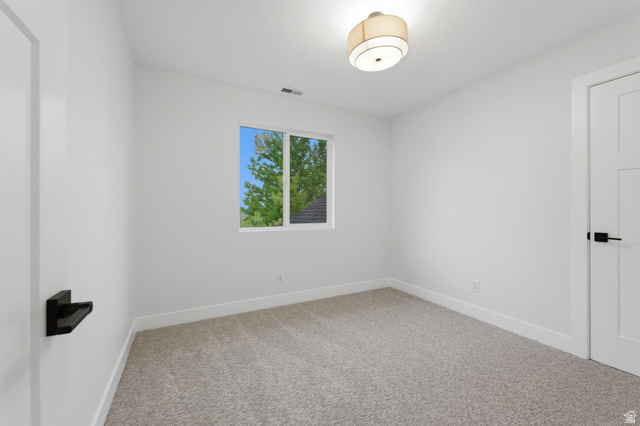 702 Alpine Highway Alpine, UT 84004 - Photo 42 of 83 Bright interior room featuring neutral carpeting, white walls, and a contemporary ceiling light fixture