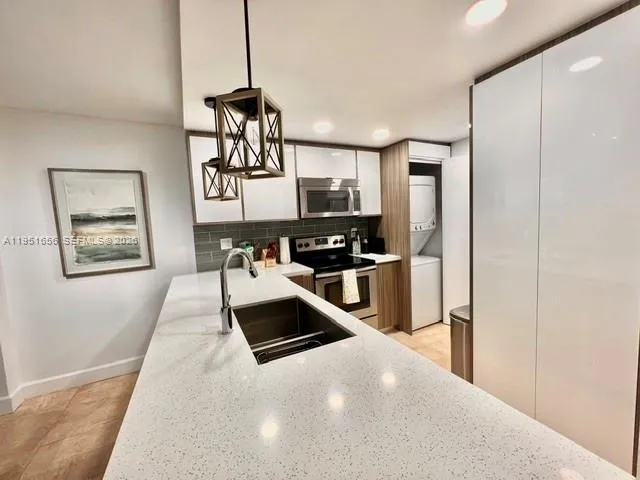 a kitchen with stainless steel appliances granite countertop a refrigerator a stove top oven a sink and dishwasher