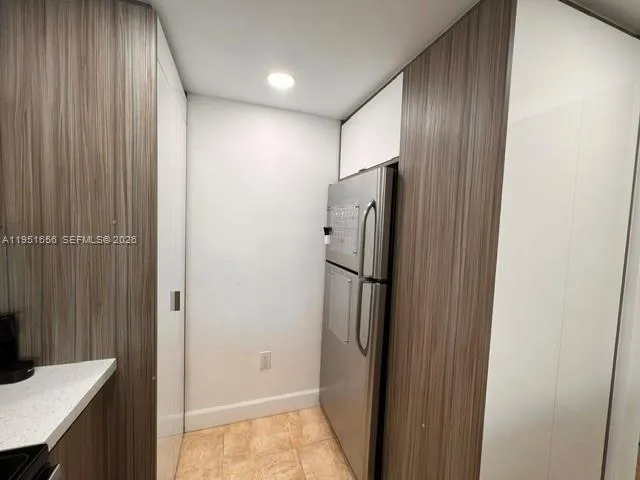 a view of a hallway with a refrigerator