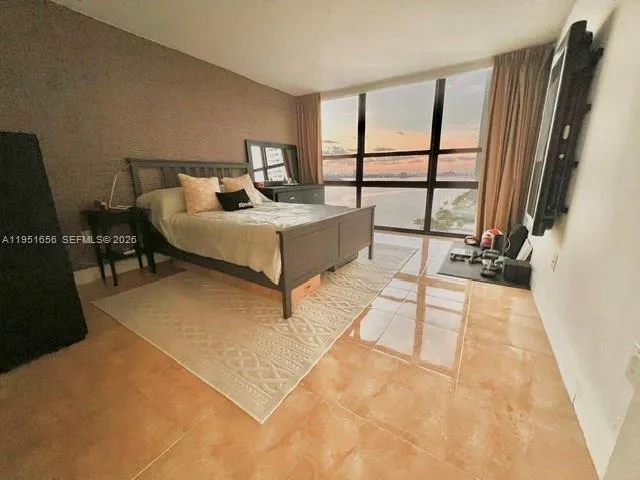 a spacious bedroom with a bed and large window