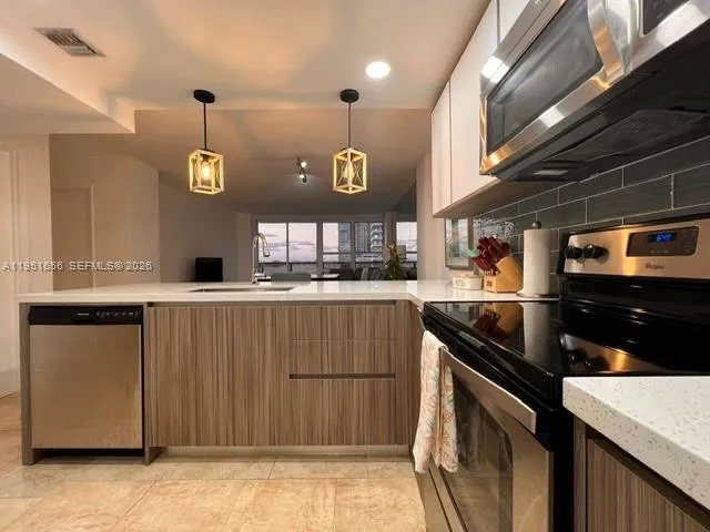 a kitchen with stainless steel appliances granite countertop a sink and a stove