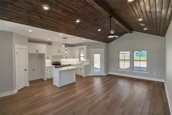 a large kitchen with stainless steel appliances granite countertop a stove and wooden floor