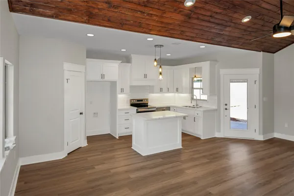 a kitchen with a refrigerator and white cabinets