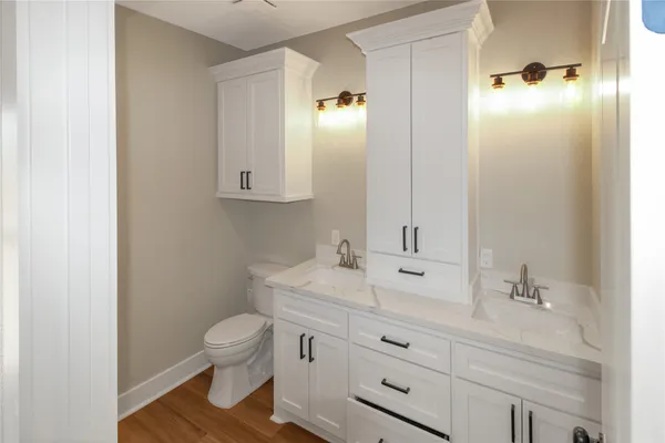 a bathroom with a sink a toilet and mirror