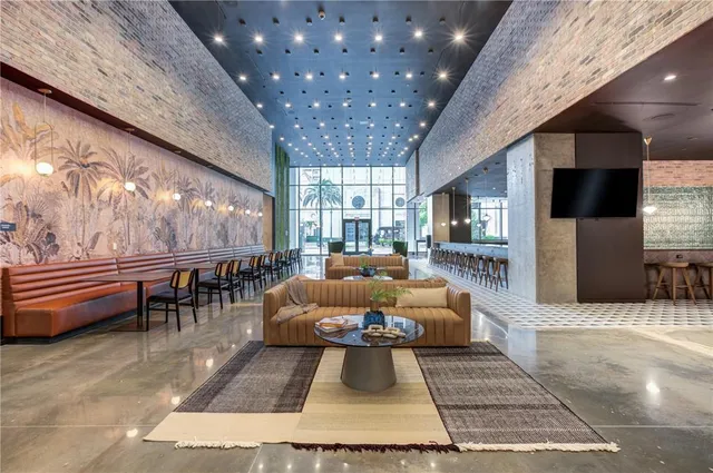 a living room with furniture a large window with kitchen view
