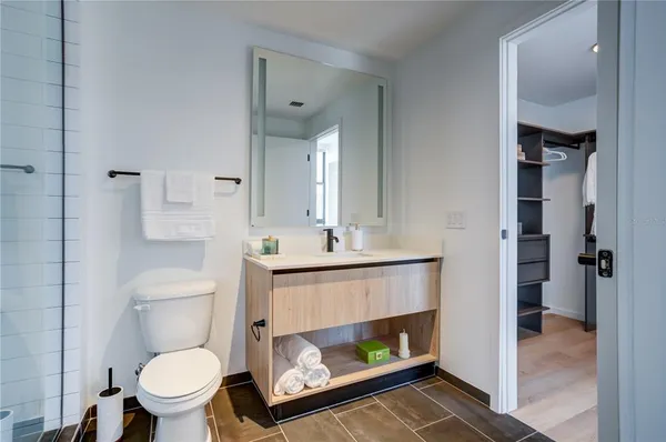 a bathroom with a toilet a sink and mirror