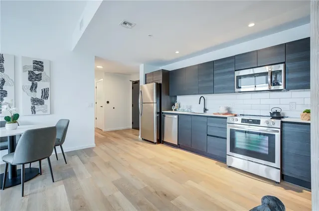 a kitchen with stainless steel appliances kitchen island granite countertop a sink and cabinets