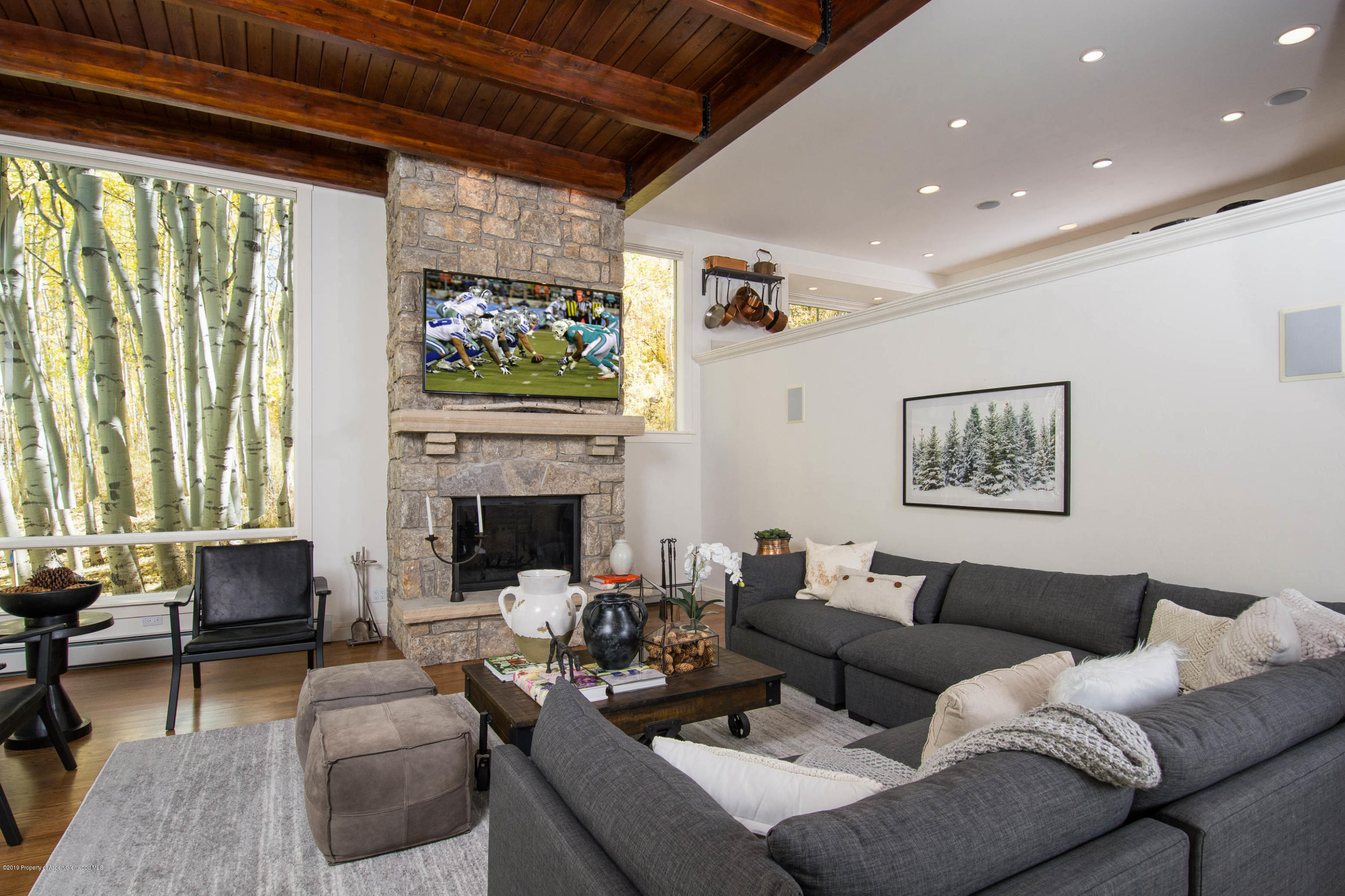 623 Faraway Road Snowmass Village, CO 81615 - Photo 2 of 30 a living room with furniture a fireplace and a floor to ceiling window