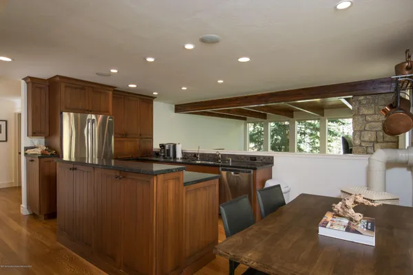 a kitchen with stainless steel appliances granite countertop a refrigerator a sink a stove and island