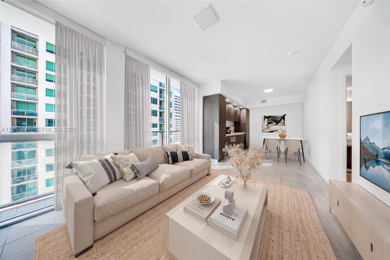 227 Northeast 2nd Street, Unit 1909 Miami, FL 33132 - Photo 2 of 18 a living room with furniture and a flat screen tv