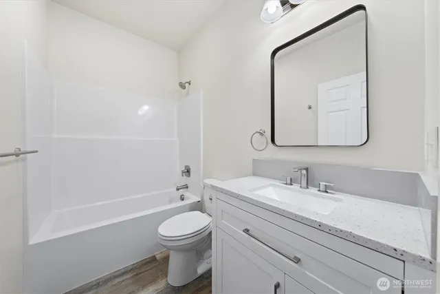 a bathroom with a toilet a sink a mirror and vanity