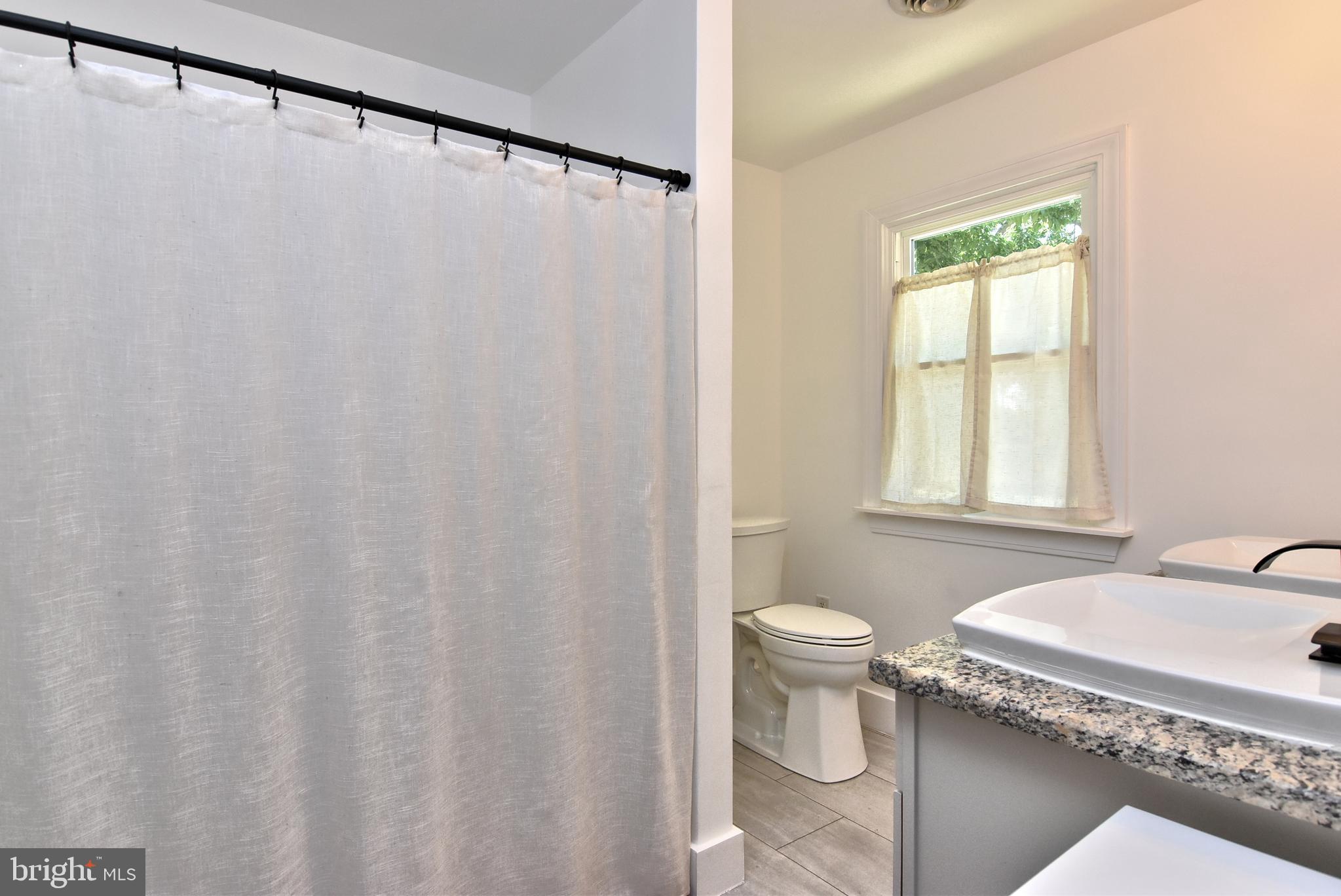 9012 Concord Road Seaford, DE 19973 - Photo 18 of 24 a bathroom with a granite countertop sink and a toilet