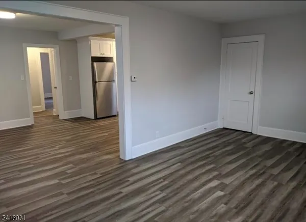 an empty room with wooden floor and closet