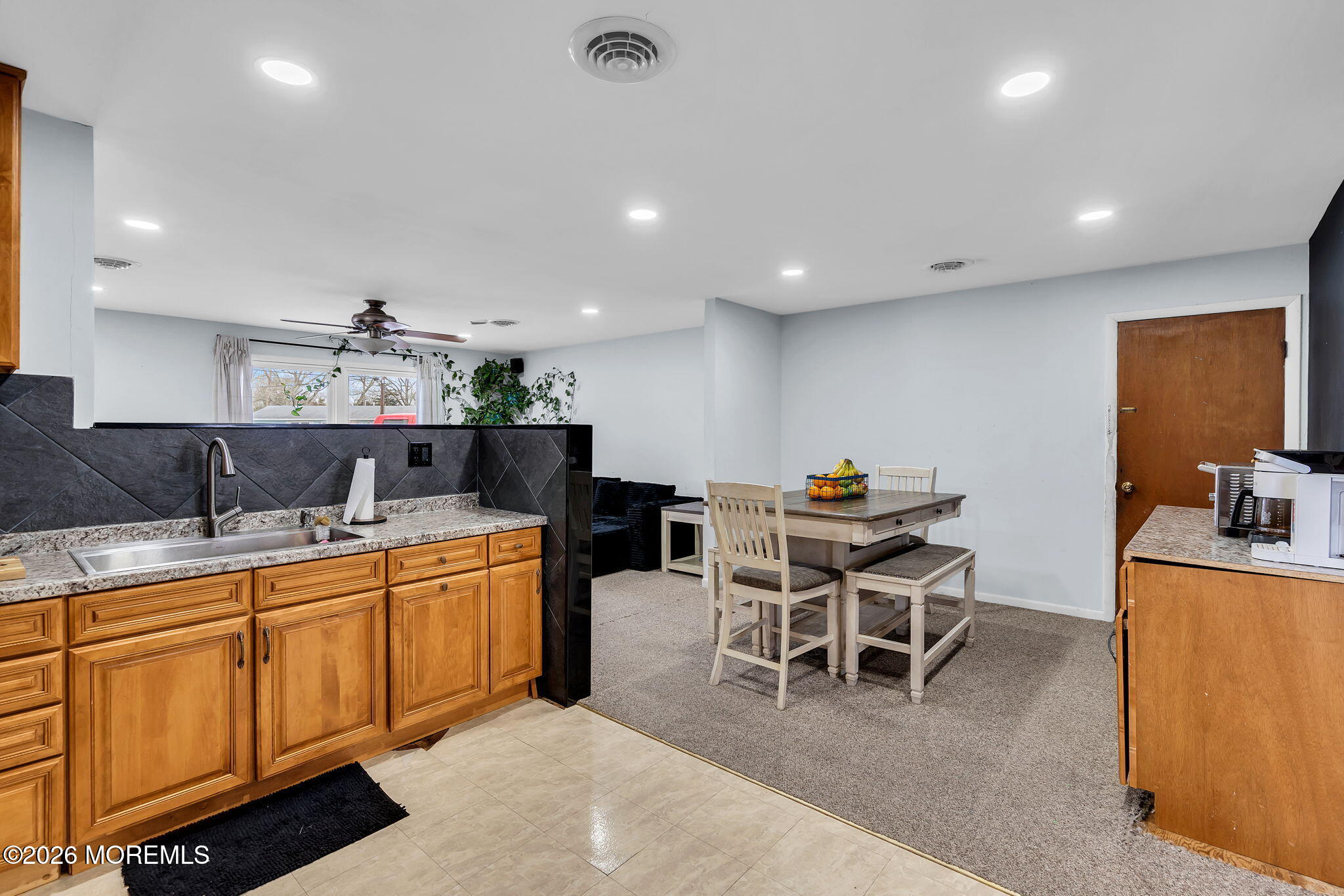 405 Decker Court Lanoka Harbor, NJ 08734 - Photo 12 of 21 a kitchen with stainless steel appliances kitchen island granite countertop a dining table chairs and sink