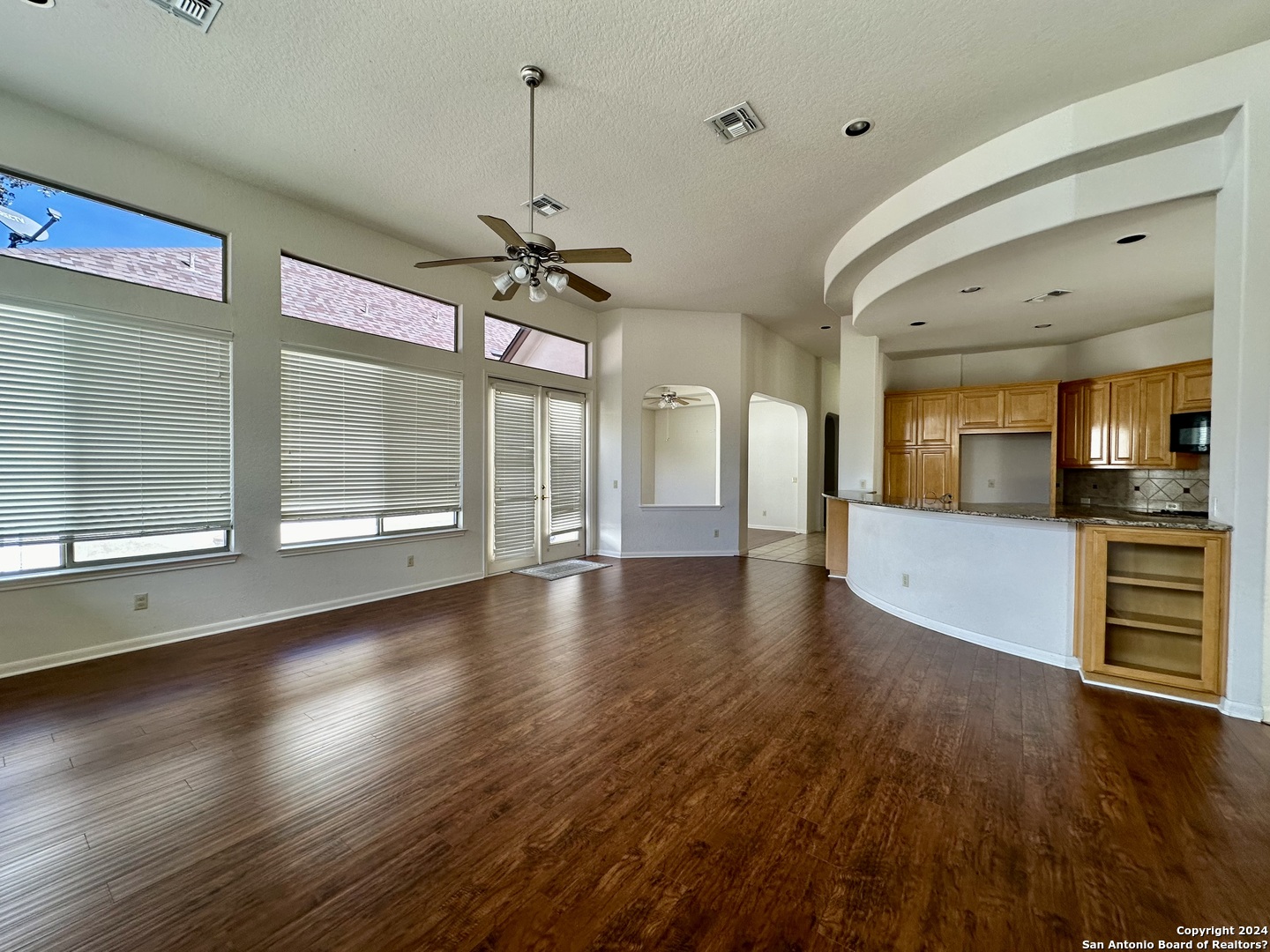 23107 Osprey Ridge San Antonio, TX 78258 - Photo 11 of 28 a view of a room with wooden floor and a kitchen