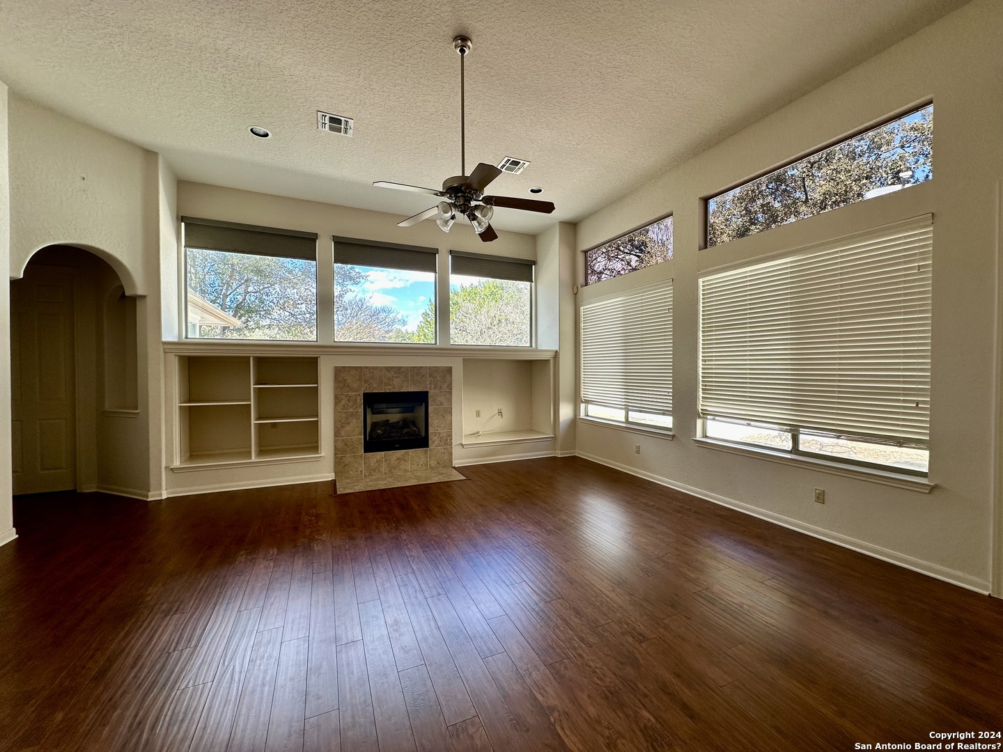 23107 Osprey Ridge San Antonio, TX 78258 - Photo 10 of 28 a view of an empty room with wooden floor fireplace and a window