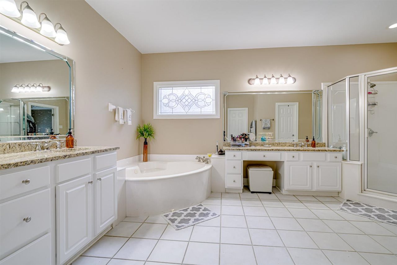 1344 Wahkin Road Collierville, TN 38017 - Photo 14 of 25 a bathroom with a sink a vanity a mirror and a bathtub