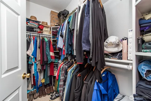 a view of walk in closet with clothes and shoes