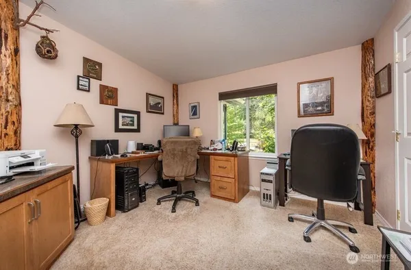 a view of a workspace with furniture and a window