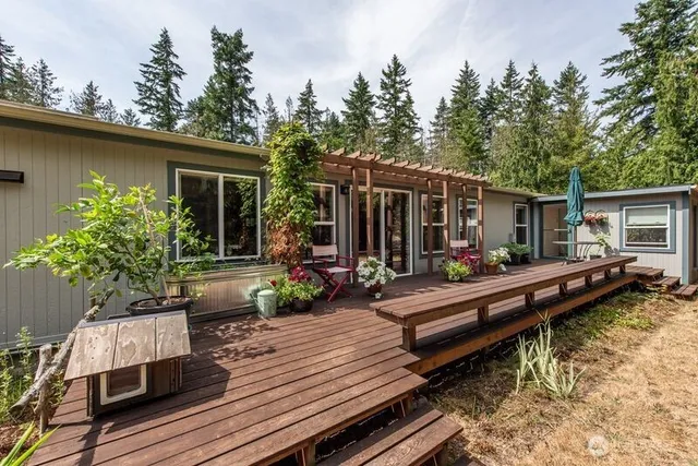 a view of a house with pool chairs in a patio