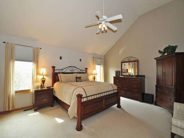 1603 Beech Street Spring Grove, IL 60081 - Photo 12 of 24 a spacious bedroom with a bed and a chandelier