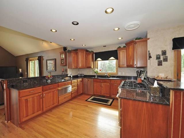 1603 Beech Street Spring Grove, IL 60081 - Photo 7 of 24 a kitchen with granite countertop a sink stove and cabinets